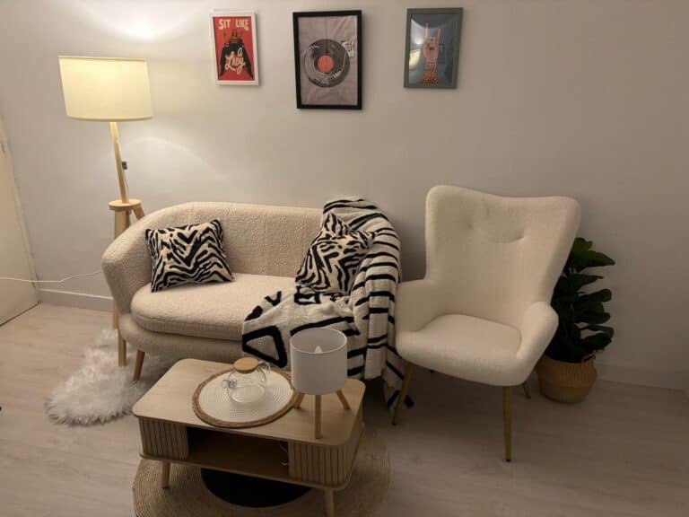 Sofá y sillón con cuadros en la pared