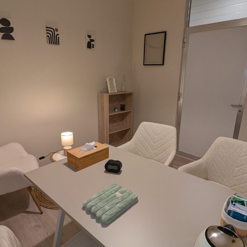 Sala de coworking con luz natural, tranquila y acogedora en Lekua, perspectiva que muestra mesa de trabajo, sillas y entrada.