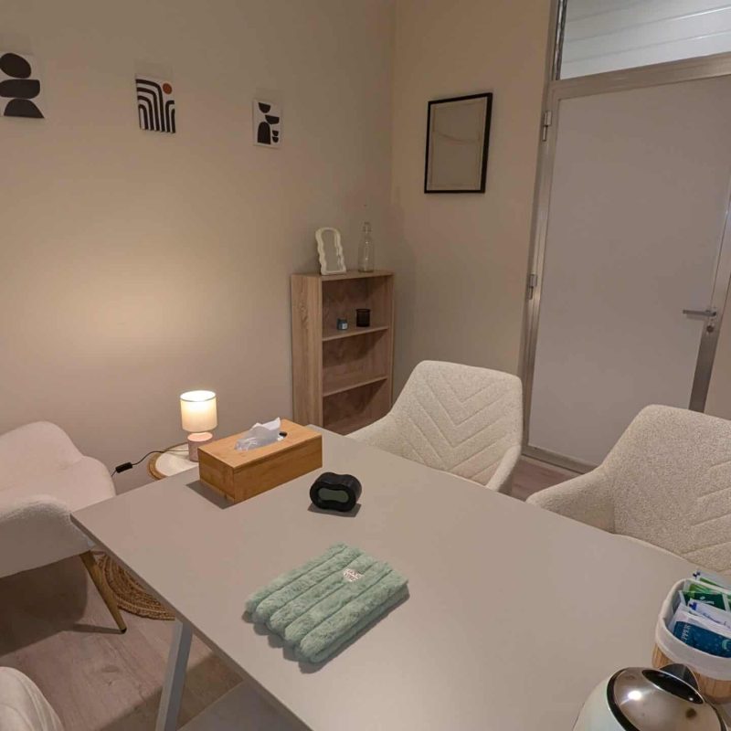Sala de coworking con luz natural, tranquila y acogedora en Lekua, perspectiva que muestra mesa de trabajo, sillas y entrada.
