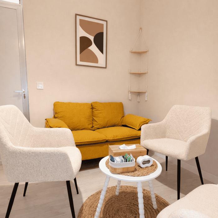 Sala de estar moderna con sillones blancos y sofá mostaza en ambiente cálido y acogedor.