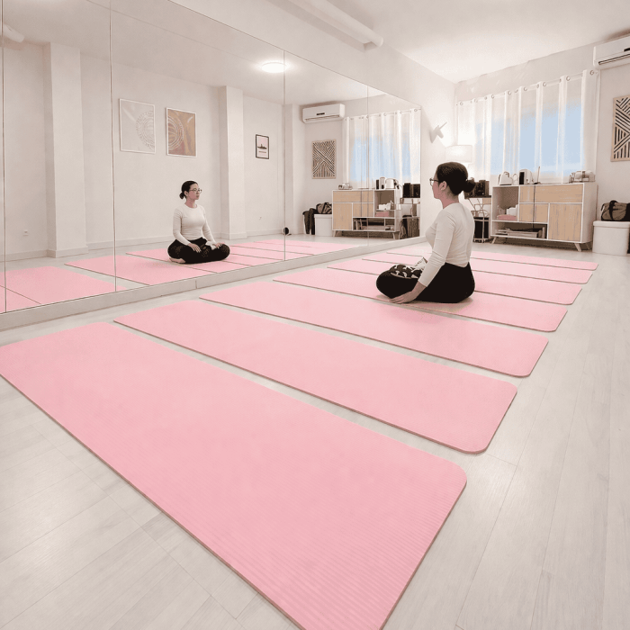 Personas practicando yoga en un estudio luminoso y tranquilo en Lekua, centro de bienestar y relajac.